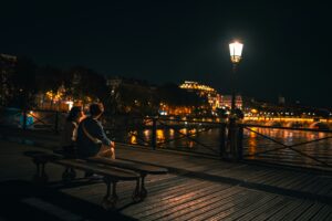 Zakochana para siedząca na ławce obserwująca miasto nocą
